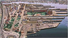 Aerial view of a waterfront industrial area with docks and buildings.